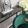 Nieduży zegar stojący z okrągłą tarczą i frontem bogato zdobionym kryształkami