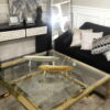 Duży kwadratowy stolik kawowy wykonany z pięknej złotej metalowej ramy i szkła hartowanego