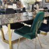 Krzesło tapicerowane obite welurem w kolorze butelkowej zieleni oraz złotymi smukłymi nogami